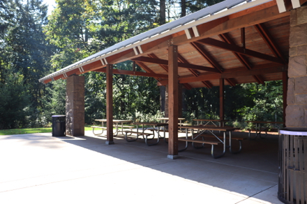 Covered picnic shelter with picnic tables inside and outside – accessible restroom
